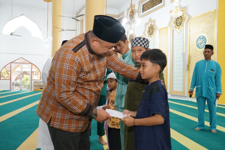 Camat Mandau, Riki Rihardi menyerahkan santunan kepada anak yatim di mesjid besar Arafah. (foto/ istimewa)