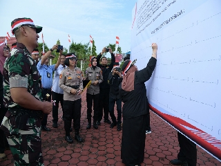Teks foto: Bupati Kasmarni saat menandatangani deklarasi menjaga keutuhan NKRI dan ciptakan pemilu damai.